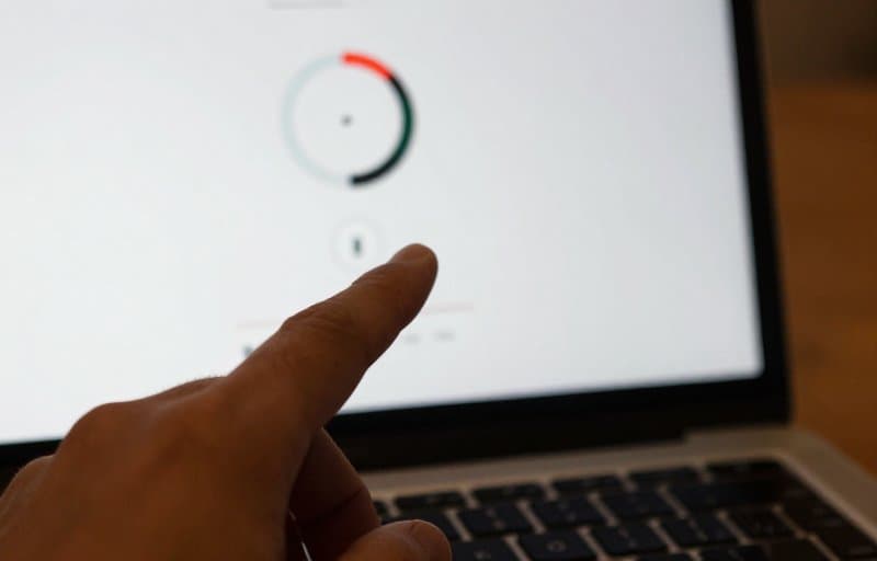 A hand pausing a phased app rollout on a laptop, illustrating how to halt a bad app update before it drives refunds