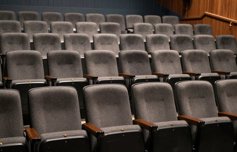 Rows of reserved seats sitting mostly empty before an event, illustrating app pre-orders that were placed but never converted into paying customers
