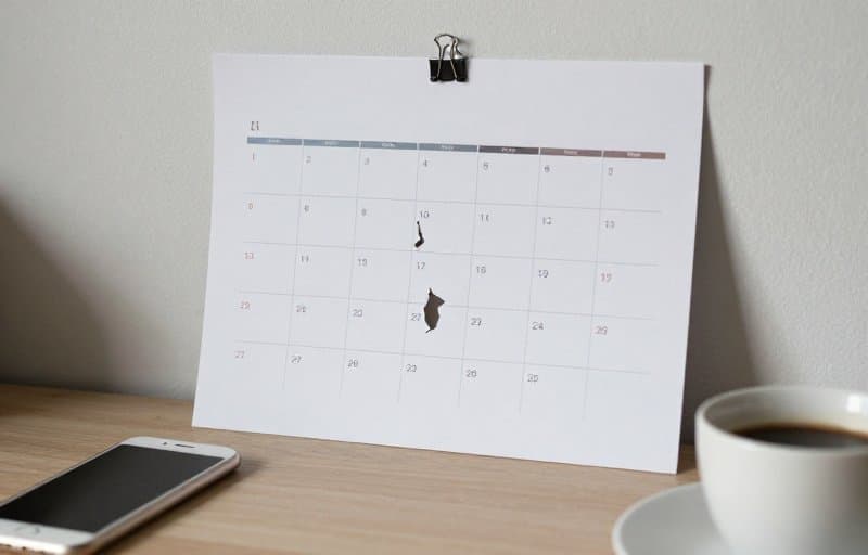 A wall calendar with its first months torn off beside a phone, illustrating how a Google Play installment subscription ends when a refund cancels the remaining monthly payments
